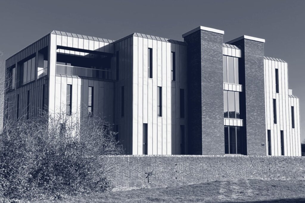Charters Mary Road building with metal cladding and brick towers, in blue-toned black and white